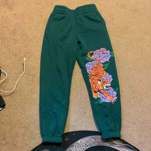 Forest green sweatpants with tiger design on the left leg